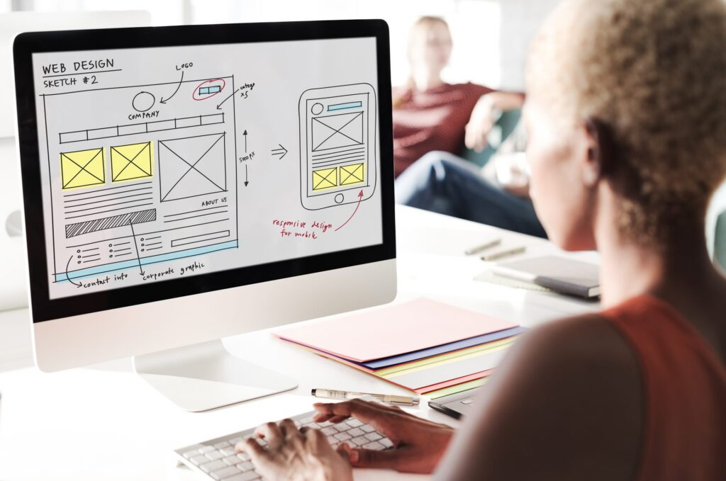 Wireframe van een webdesign op een computerscherm met notities over responsive design